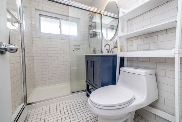 bathroom featuring toilet, a stall shower, tile walls, and tile patterned floors