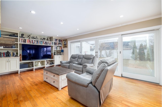 living room featuring light wood-type flooring, crown molding, and recessed lighting