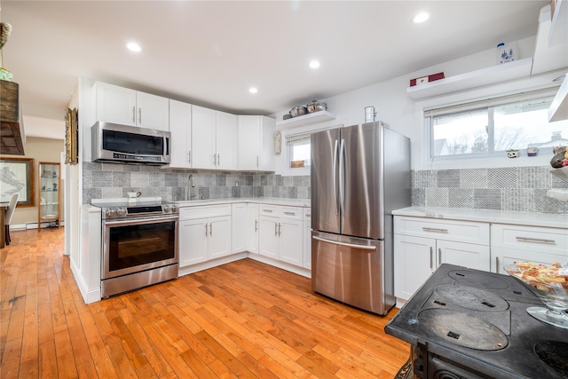 kitchen with white cabinets, a healthy amount of sunlight, stainless steel appliances, and light countertops