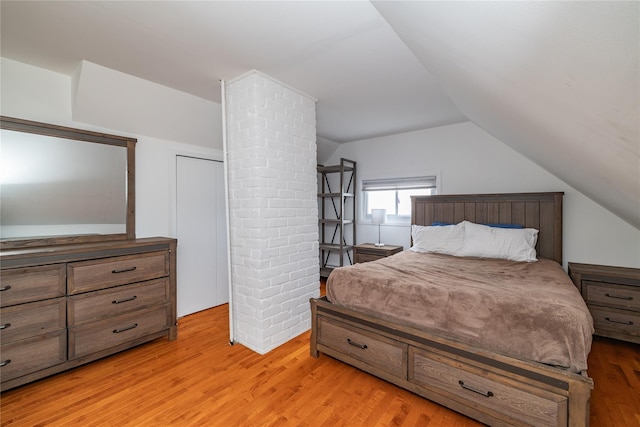 bedroom featuring vaulted ceiling and light wood finished floors