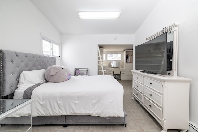 bedroom with light tile patterned floors, a baseboard radiator, multiple windows, and vaulted ceiling