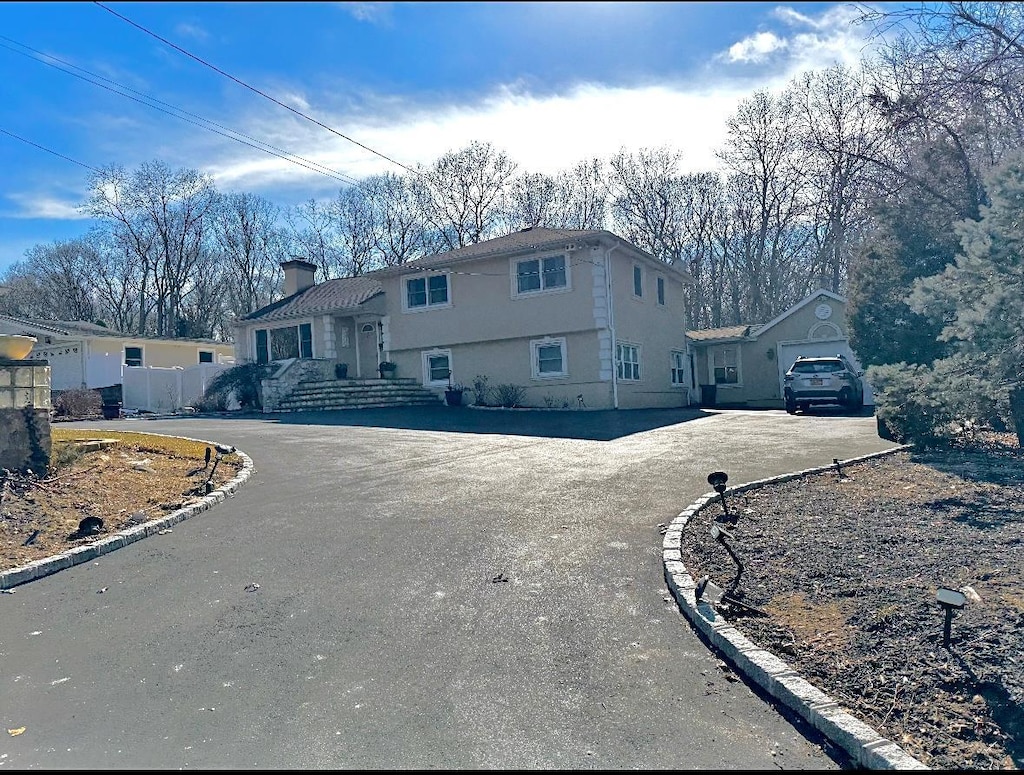 163 Deforest Rd, Dix Hills, NY 11746 - tri-level home featuring a chimney, fence, aphalt driveway, and stucco siding