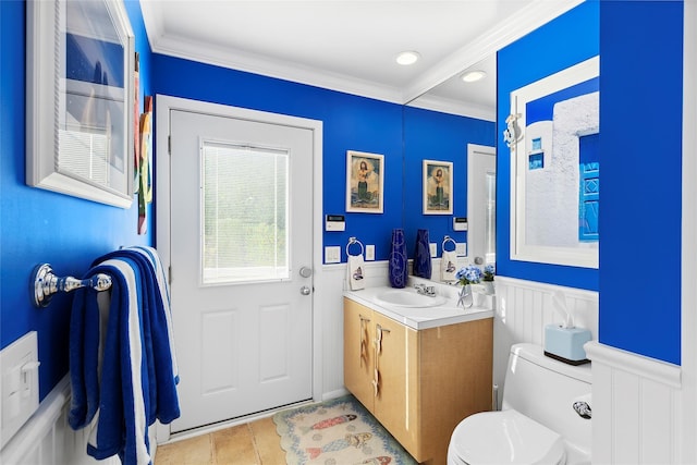 bathroom with wainscoting, vanity, toilet, and crown molding