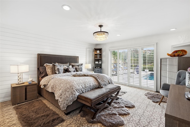 carpeted bedroom featuring a chandelier, access to outside, wood walls, and recessed lighting