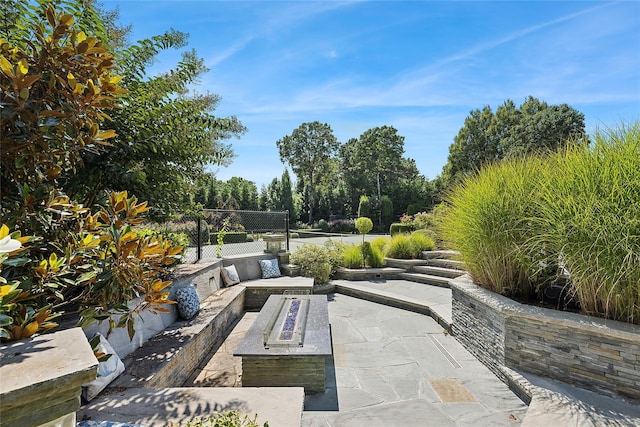 view of patio / terrace with an outdoor fire pit and fence