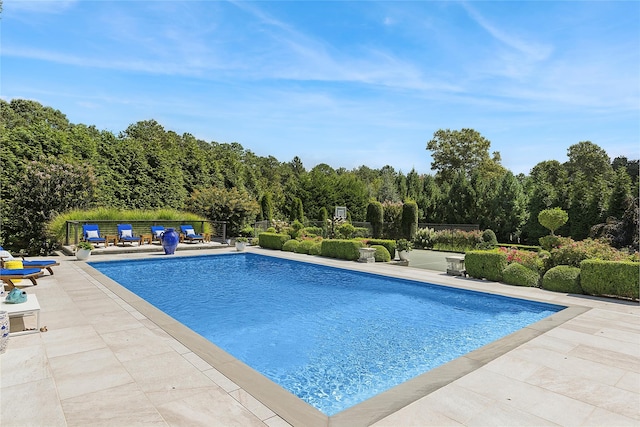 pool with a patio area and fence