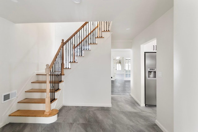 stairs featuring baseboards and visible vents