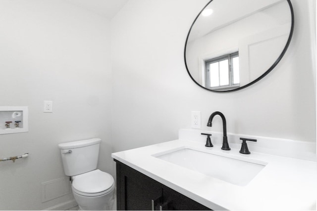 half bathroom featuring toilet and vanity