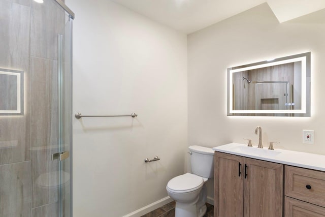 bathroom featuring toilet, a stall shower, baseboards, and vanity