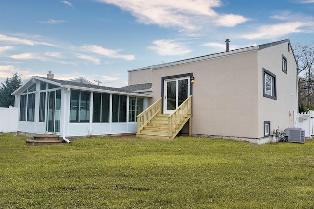 rear view of house featuring a lawn, cooling unit, fence, and a sunroom