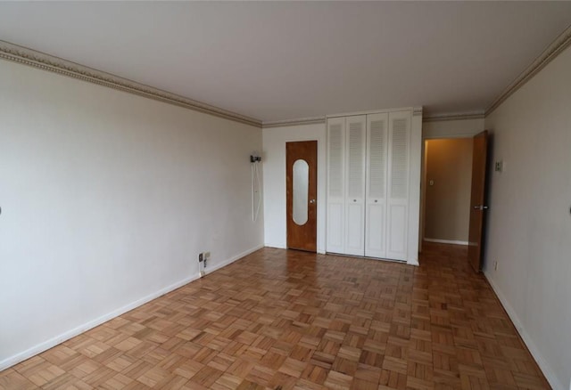 unfurnished bedroom featuring a closet, crown molding, and baseboards