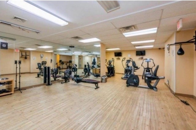 gym with wood finished floors, visible vents, and a drop ceiling