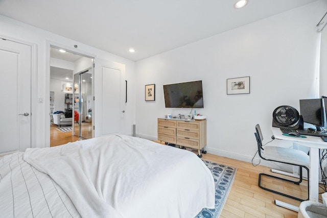 bedroom with baseboards, wood finished floors, and recessed lighting