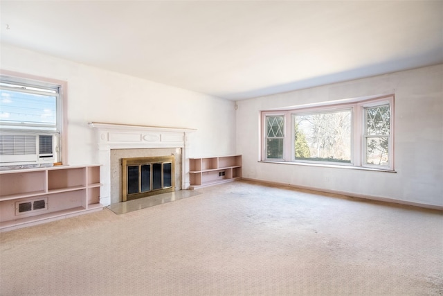 unfurnished living room featuring carpet, a high end fireplace, visible vents, and baseboards