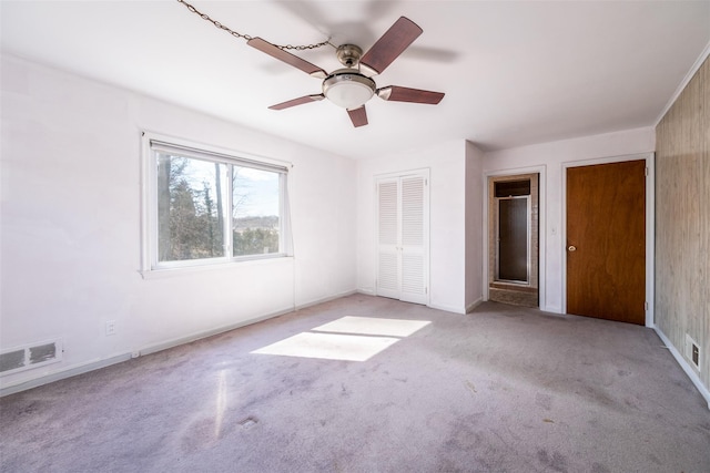 unfurnished bedroom with carpet, visible vents, ceiling fan, and baseboards