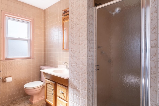 bathroom featuring toilet, vanity, a shower stall, and tile walls