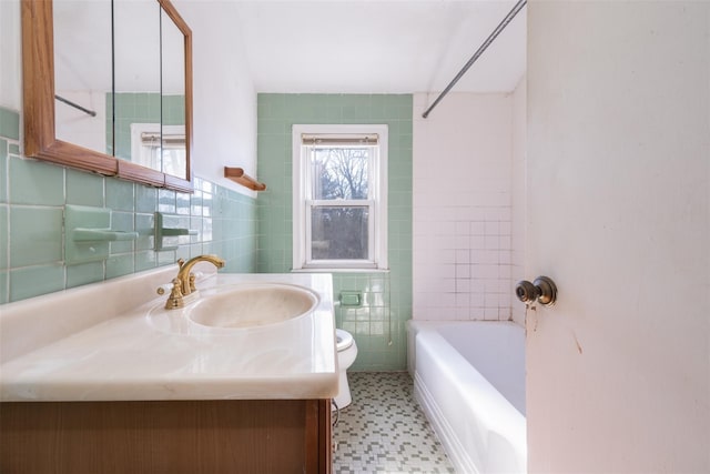 bathroom with toilet, vanity, tile walls, and tile patterned floors