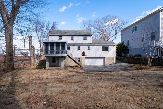 back of house with a garage, a sunroom, and stairway