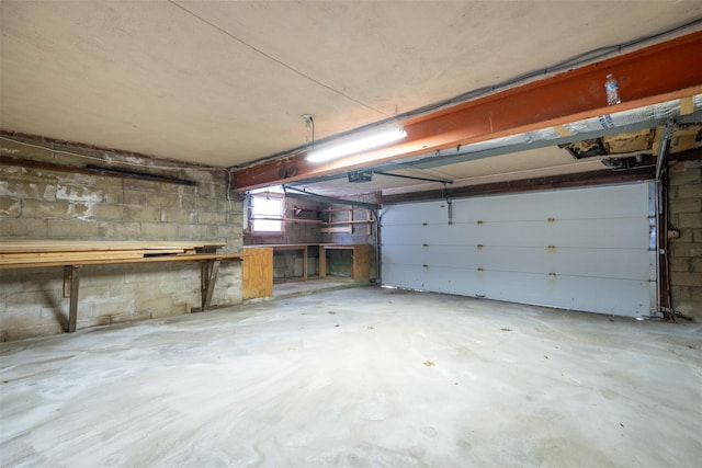 garage with a garage door opener and concrete block wall