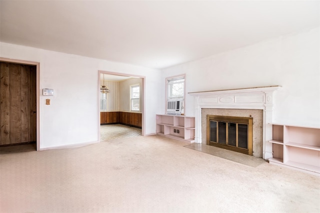 unfurnished living room featuring cooling unit, carpet flooring, a fireplace, and baseboards