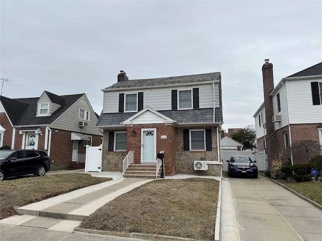 view of front of home featuring concrete driveway, brick siding, and a chimney