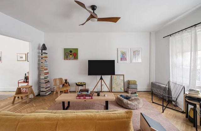 living room featuring ceiling fan and baseboards