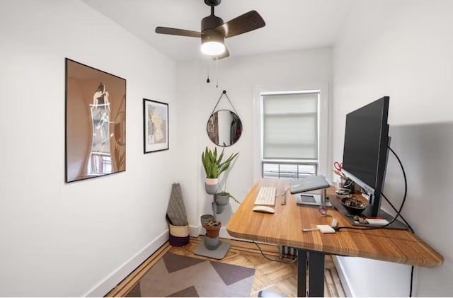 office area with ceiling fan and baseboards