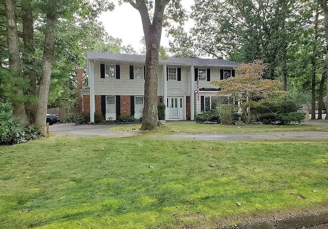 view of front of house with brick siding and a front yard