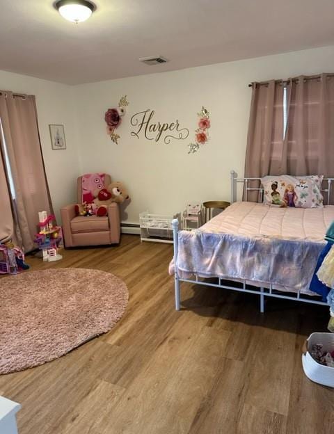 bedroom featuring visible vents and wood finished floors