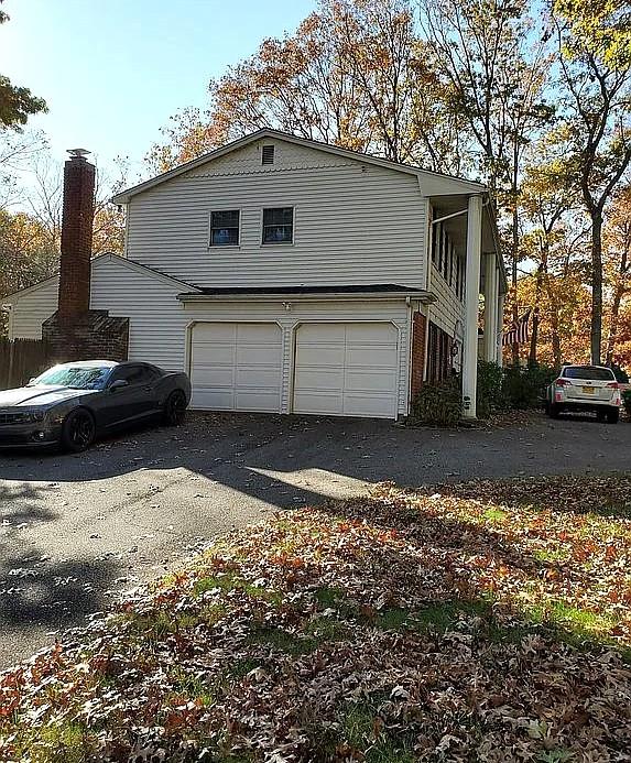 view of side of property with a garage and aphalt driveway