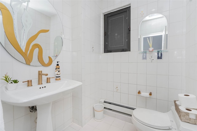 half bathroom featuring tile patterned floors, toilet, tile walls, and a baseboard radiator