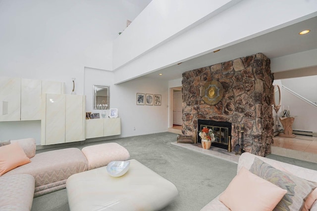 carpeted living area with recessed lighting, a fireplace, baseboards, and a towering ceiling