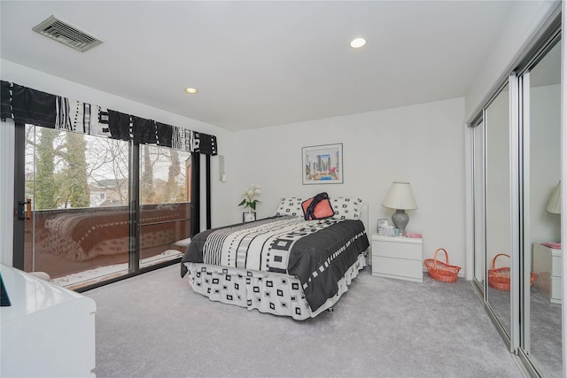 carpeted bedroom featuring a closet, visible vents, recessed lighting, and access to outside