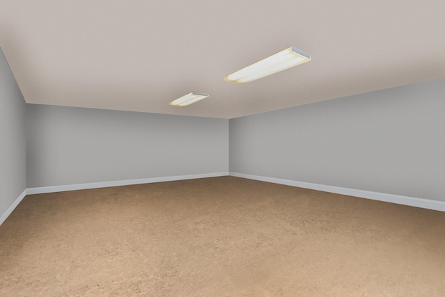 empty room with lofted ceiling and baseboards