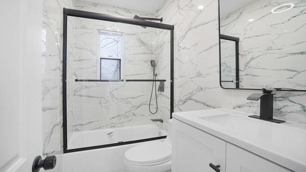 full bathroom featuring toilet, enclosed tub / shower combo, and vanity