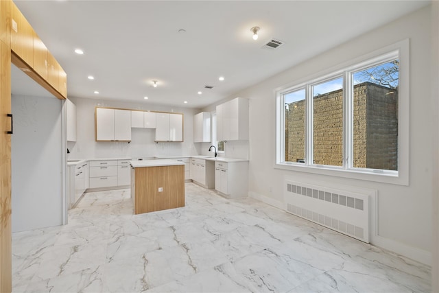 kitchen featuring radiator, recessed lighting, visible vents, and a center island