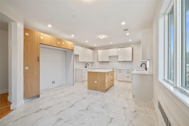 kitchen with recessed lighting, a kitchen island, modern cabinets, and radiator heating unit