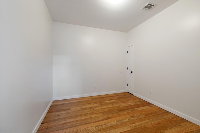 unfurnished room with visible vents, light wood-style flooring, and baseboards