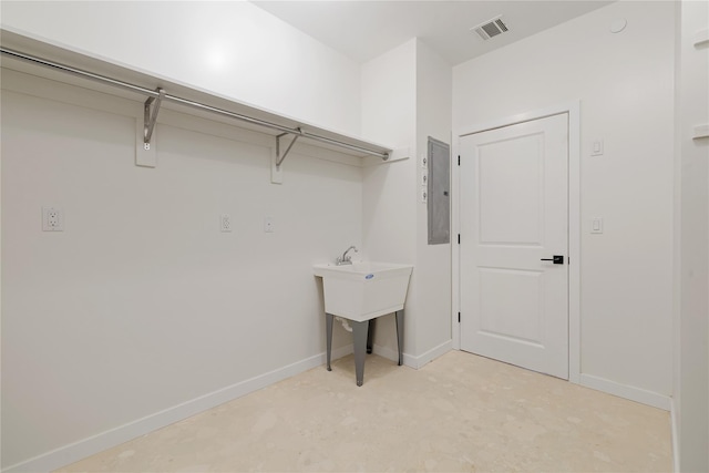 clothes washing area featuring electric panel, baseboards, and visible vents