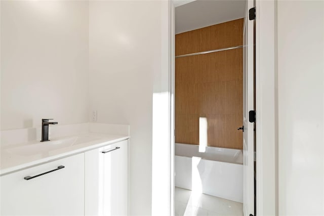 bathroom featuring vanity and a bath