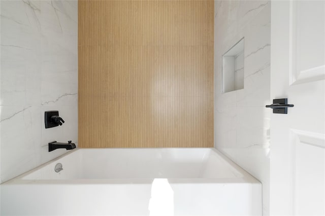 bathroom featuring tile walls and a tub to relax in