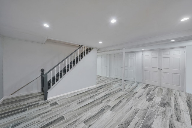 below grade area with stairs, ornamental molding, wood finished floors, and recessed lighting