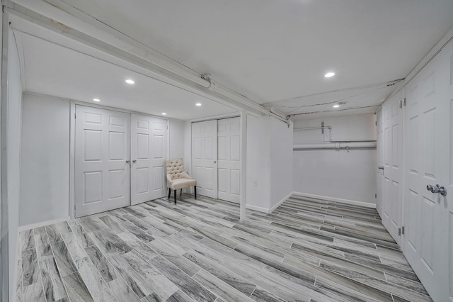 finished below grade area with recessed lighting, light wood-style flooring, and baseboards