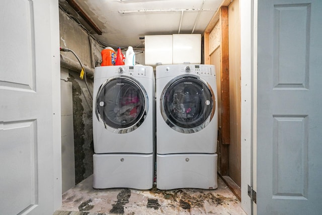 laundry area featuring washing machine and clothes dryer and cabinet space