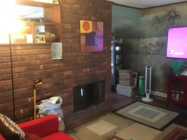 living area with a brick fireplace, a baseboard radiator, and crown molding