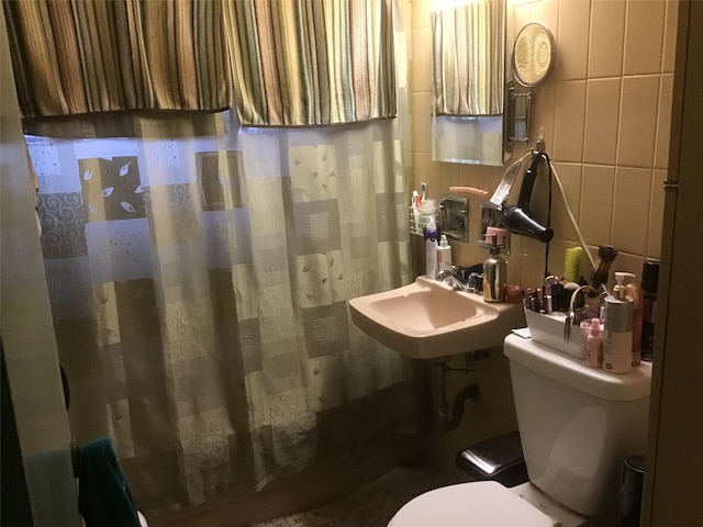 bathroom featuring a shower with shower curtain, a sink, and toilet