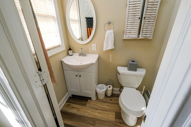 bathroom featuring vanity, toilet, wood finished floors, and baseboards