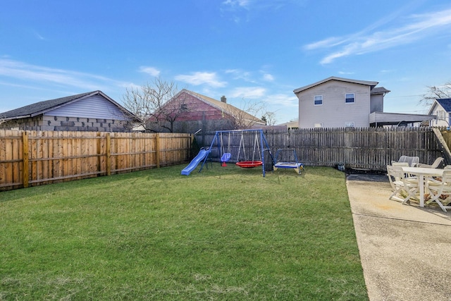 view of yard with a patio area, a fenced backyard, and a playground