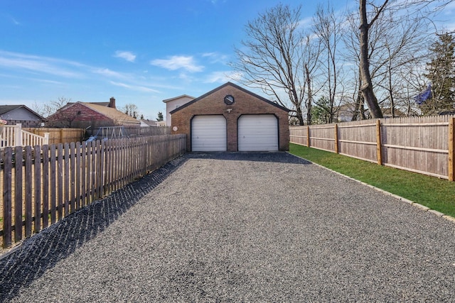 detached garage with driveway and fence