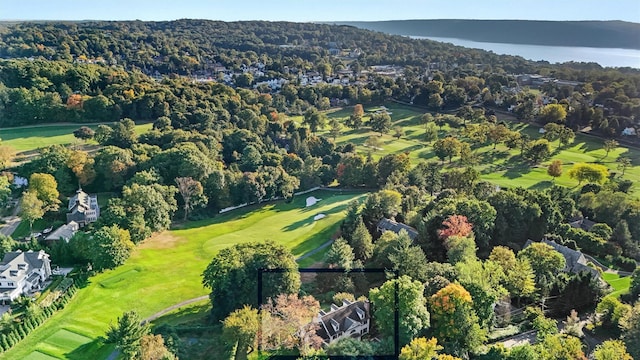 birds eye view of property with view of golf course and a wooded view